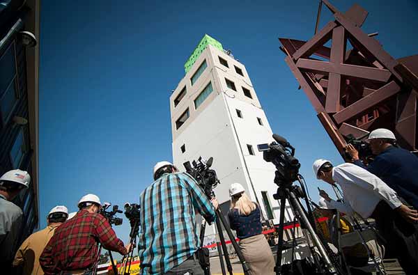 Image: Reporters prepare to record a test on a five-story building equipped with a wide range of non-structural components, such as an elevator and sprinklers, at the UC San Diego shake table in April 2012.