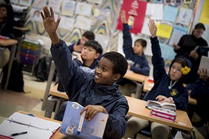 Student raising his hand in the classroom at The Preuss School
