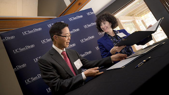 Jackson Yang and Elizabeth H. Simmons signing agreement