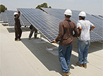 Photo of workers installing solar photovoltaic panels on a building at UC San Diego