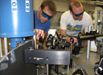 Photo of Alex High and Aaron Hammack adjust the optics in their UCSD lab.