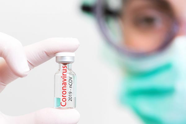 Doctor holding coronavirus vial - Photo by iStock_herraez