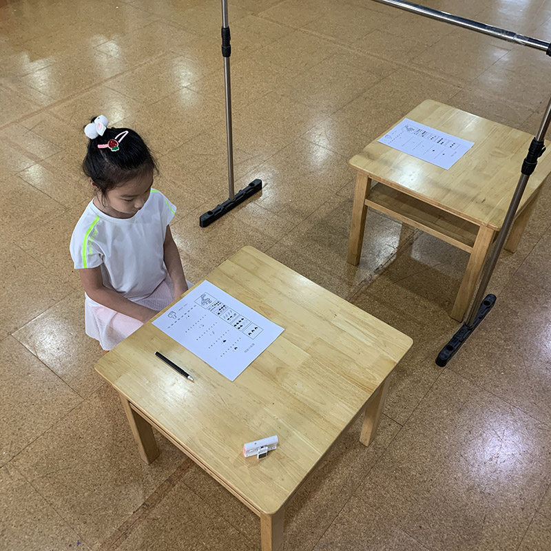 Girl taking test with barrier frame.