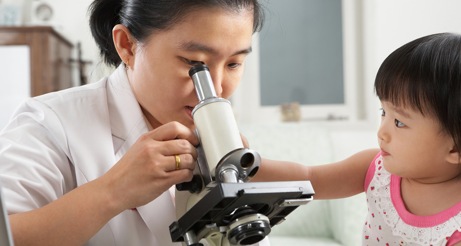 Woman at microscope with child