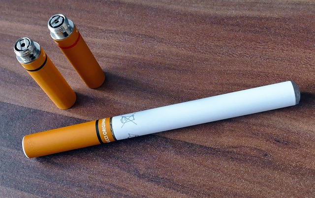 E-cigarette and cartridges on a wooden tabletop. 