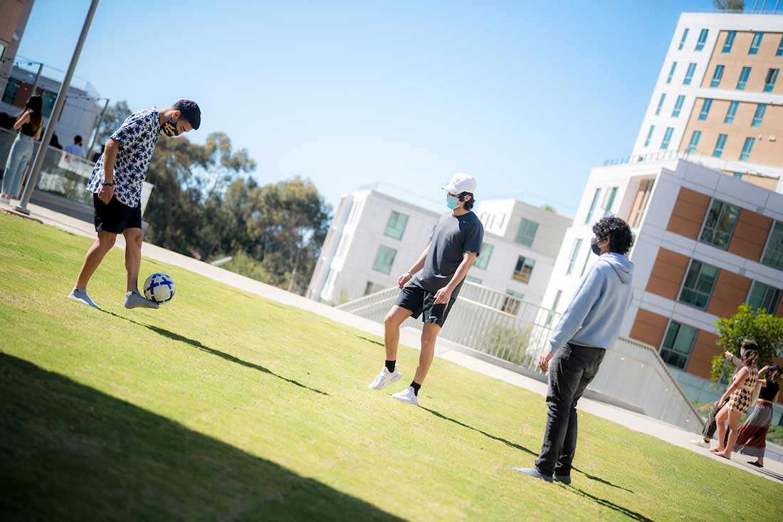 Students playing soccer on campus.