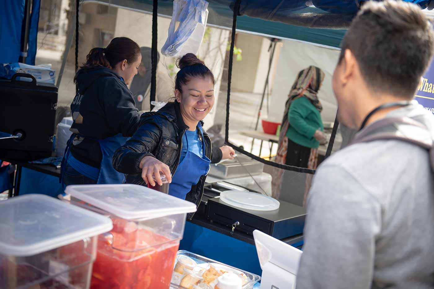 Cashier at food booth handing drink to student